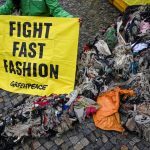 Ativistas do Greenpeace protestam no Portão de Brandemburgo contra a poluição do meio ambiente em Gana causada por roupas de fast fashion como resíduos plásticos.